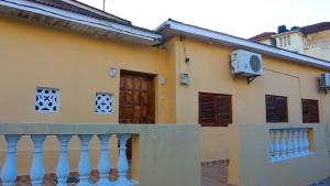 a yellow house with a balcony and a door at Bandari House Malindi in Zanzibar City