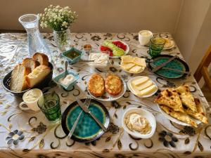 a table topped with plates of bread and cheese at Ivlita in Mestia +15 photos