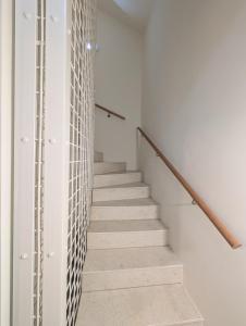 a staircase in a house with white walls and white stair railing at Maison Bruxelles in Brussels