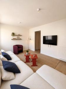 a living room with two white couches and a flat screen tv at Maison Bruxelles in Brussels