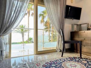 a room with a large window with a view of the ocean at 7 Bdr Villa with Heated Pool & Spa in Mazotos