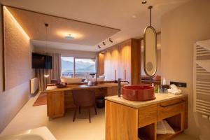 a bathroom with a sink and a desk with a mirror at Hotel Schönblick in Rodengo