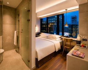 a bedroom with a large bed and a bathroom with a window at Hotel Relax 5 in Taipei