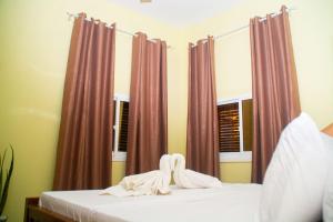 a bedroom with a bed with pink curtains at Bandari House Malindi in Zanzibar City