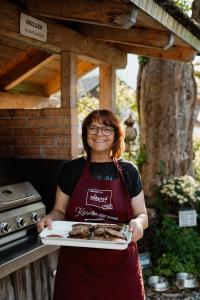 a woman is holding a plate of food at Gästehaus Berger in Tröpolach