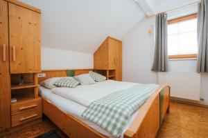 a bedroom with a bed with a wooden headboard at Gästehaus Berger in Tröpolach