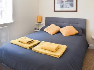 a blue bed with two towels on top of it at Coops Nest in Stalham