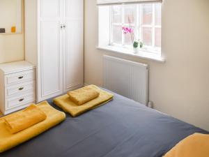 a bedroom with a bed with two yellow pillows at Coops Nest in Stalham