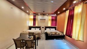 two beds in a room with a table and chairs at Sand Dunes Stay in Bagru