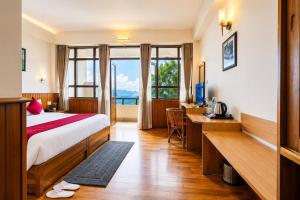a hotel room with a bed and a desk and window at Sparrow Chiminda A-Heritage Hotel Middle Pelling in Pelling +154 photos