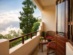 a balcony with a table and chairs and a window at Sparrow Chiminda A-Heritage Hotel Middle Pelling in Pelling