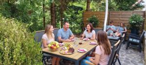 Eine Gruppe von Menschen sitzt an einem Tisch und isst Essen in der Unterkunft FOREST RETREAT Luxury Villas in Buşteni + 47 Fotos