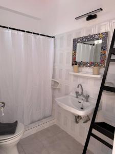 a bathroom with a shower curtain and a sink at Angelika Rooms in Longá +21 photos