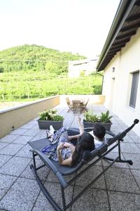 two people laying on a chair on a patio at Corte Nascimben in Marano di Valpolicella