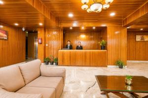 two men in a lobby with a reception desk at Sparrow Chiminda A-Heritage Hotel Middle Pelling in Pelling