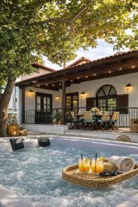 a house with a swimming pool with a tray of drinks at Villa Shada's pool & Jacouzi in Nea Irakleia