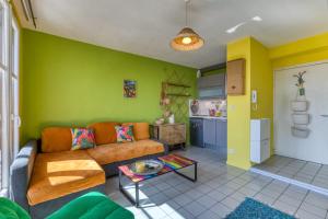 a living room with a couch and a kitchen at Le Duplex des Halles-Balcon & Clim in Sète