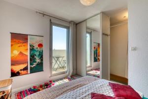 a bedroom with a bed and a large window at Le Duplex des Halles-Balcon & Clim in Sète