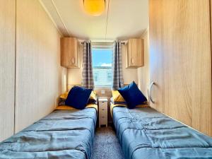 two beds in a small room with a window at Dale 12 in Burgh Island +27 photos