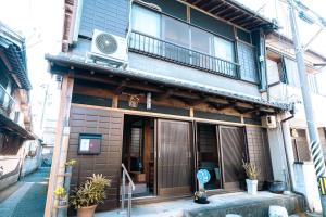 a building with a balcony on the side of it at 民泊豊久 in Nigō