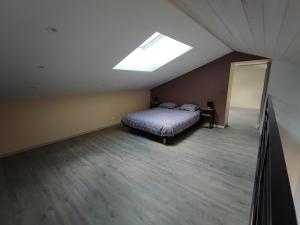 a attic bedroom with a bed and a skylight at Augustobona in Lévigny +8 photos