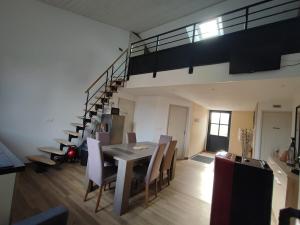 a living room with a dining room table and stairs at Augustobona in Lévigny