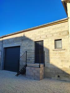 a brick building with a staircase and a garage at Augustobona in Lévigny