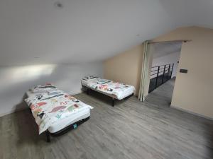 two beds in a room with a hallway with a door at Augustobona in Lévigny