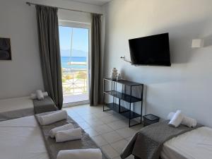 a hotel room with two beds and a television at Angelika Rooms in Longá
