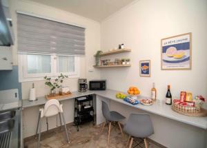 a kitchen with a counter with chairs and a table at Alivio Country House in Nafplio