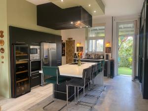 a kitchen with a large island with a table and chairs at Maison Marély in Chantonnay
