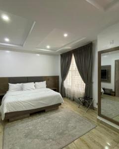 a bedroom with a large bed and a large mirror at Blooms Manor Apartment in Lagos +73 photos