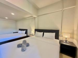 a bedroom with two beds and two lamps at Simply Stay Chaweng in Chaweng