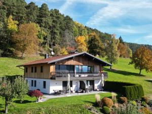 a house in the middle of a field with trees at Appartament Eichnerhof in Chienes