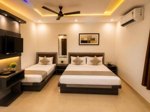 a bedroom with two beds and a ceiling fan at Hotel Shekhawati Resort -Parking Restaurant Near Toran Dwar in Khātu +117 photos