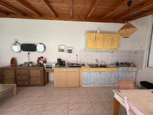 a large kitchen with wooden cabinets and a tv at Angelika Rooms in Longá