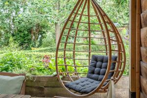 a swing chair sitting on a porch at Toad Hall Lodges - Luxury Glamping Lodges Near Southwold! in Wangford
