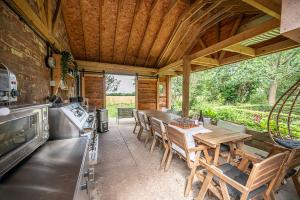 a kitchen with a table and chairs in a cabin at Toad Hall Lodges - Luxury Glamping Lodges Near Southwold! in Wangford