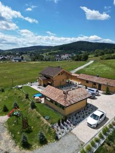 an aerial view of a house with a car parked in a parking lot at Domki Pod Łanem in Tylicz