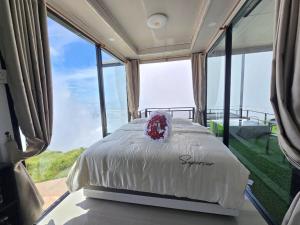 a bedroom with a bed in a room with large windows at Memory เมมโมรี่ ภูทับเบิก in Ban Maeo Thap Boek