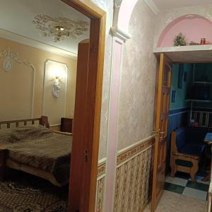 an open door to a bedroom with a bed and a chair at Квартира in Sumy