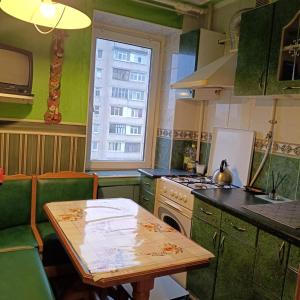 a kitchen with a table and a stove and a window at Квартира in Sumy