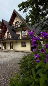 a house with purple flowers in front of it at Gościniec w Zakopanem in Zakopane