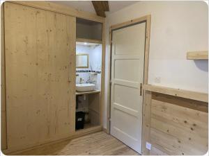 a bathroom with a wooden door and a sink at Appartement chaleureux cité vauban à Briançon in Briançon