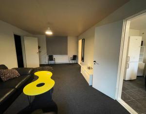 a living room with a couch and a yellow table at Cozy & Private House in Roslev