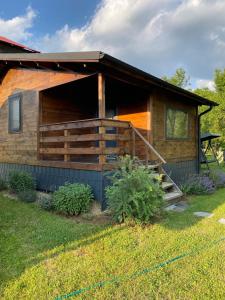 a log cabin with a porch and a deck at Bungalouri Olanesti in Băile Olăneşti +64 photos