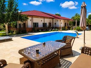 a patio with a table and chairs next to a pool at Cappadociagarden in Kutaisi