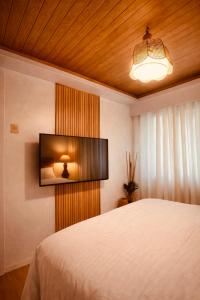 a bedroom with a bed and a television on the wall at Terravive in Manila +34 photos