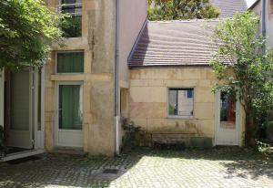 an old building with two doors and a window at Maison Wilson - Dijon centre - very quiet in Dijon
