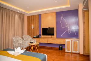 a hotel room with a bed and a flat screen tv at Gautam Hotel Dhanusha in Lālbhitti